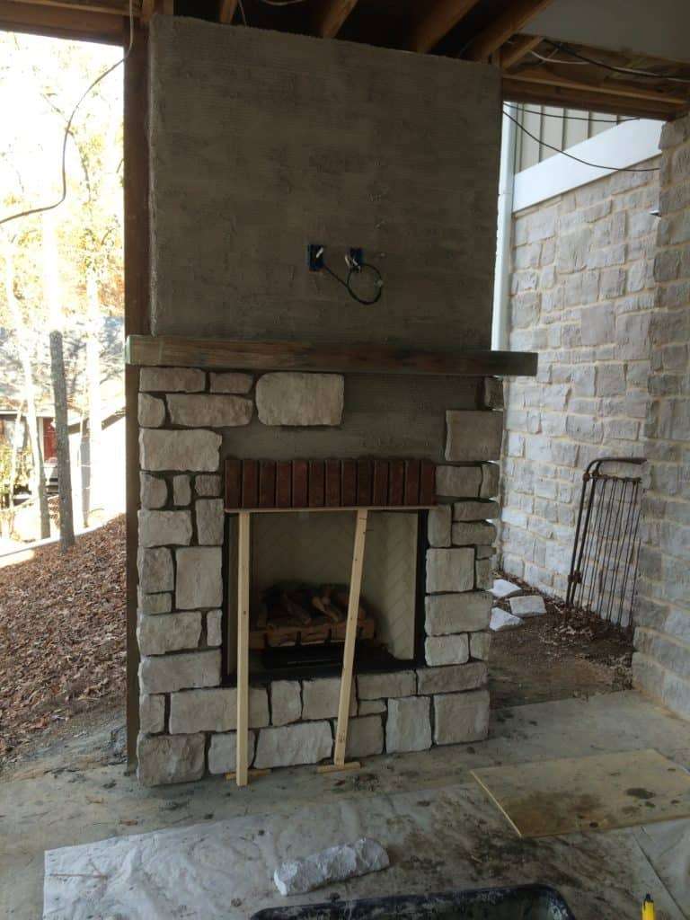outdoor fireplace under construction with gray stone partially installed