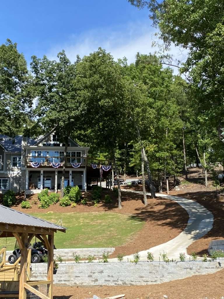 house, retaining wall, and path to lake